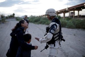 Eine guatemaltekische Frau bittet ein Mitglied der mexikanischen Nationalgarde, sie in Ciudad Juárez in die USA einreisen zu lassen. © José Luis González - Reuters
